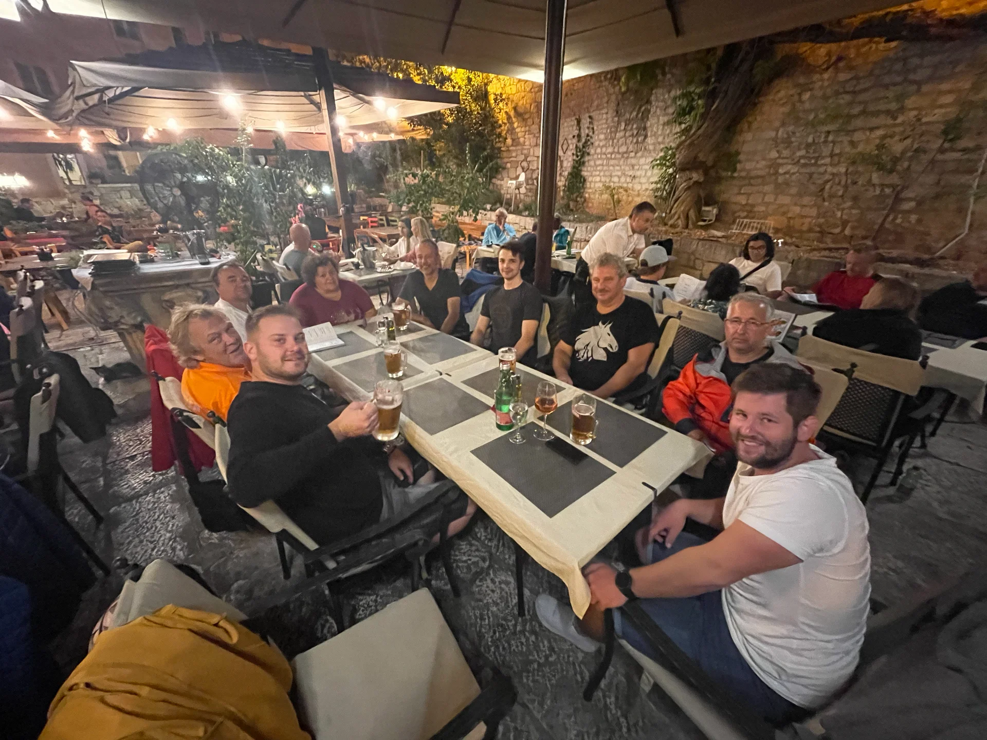 skupina lidí sedících u stolů s pitím