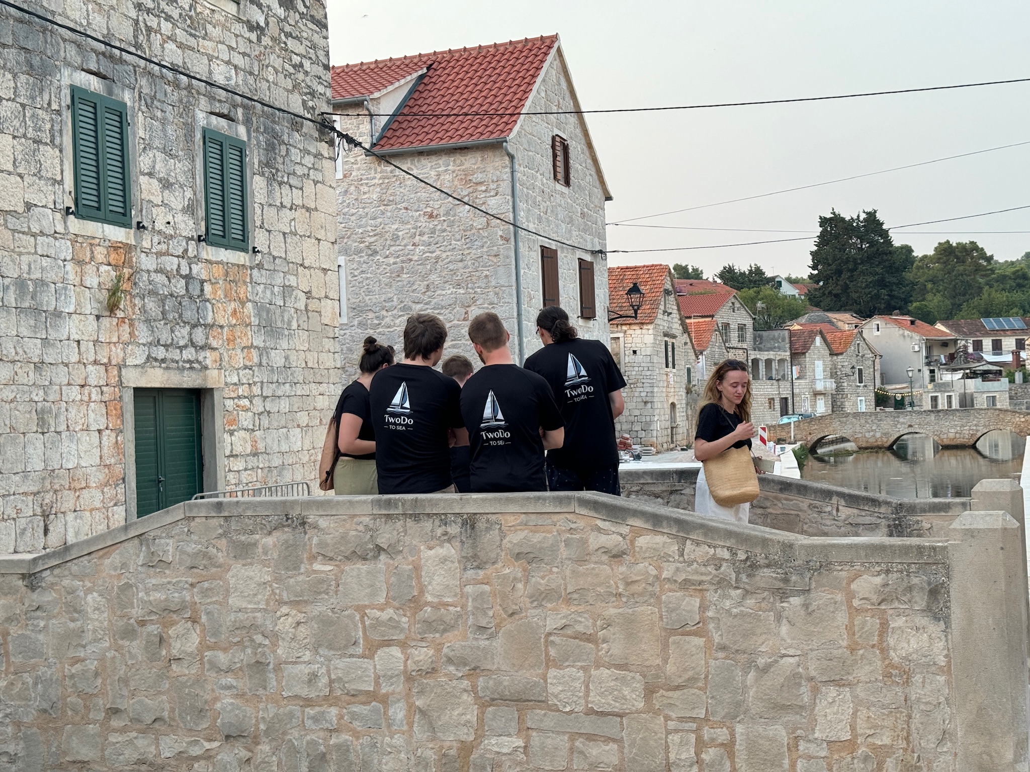 skupina lidí stojících na kamenné zdi