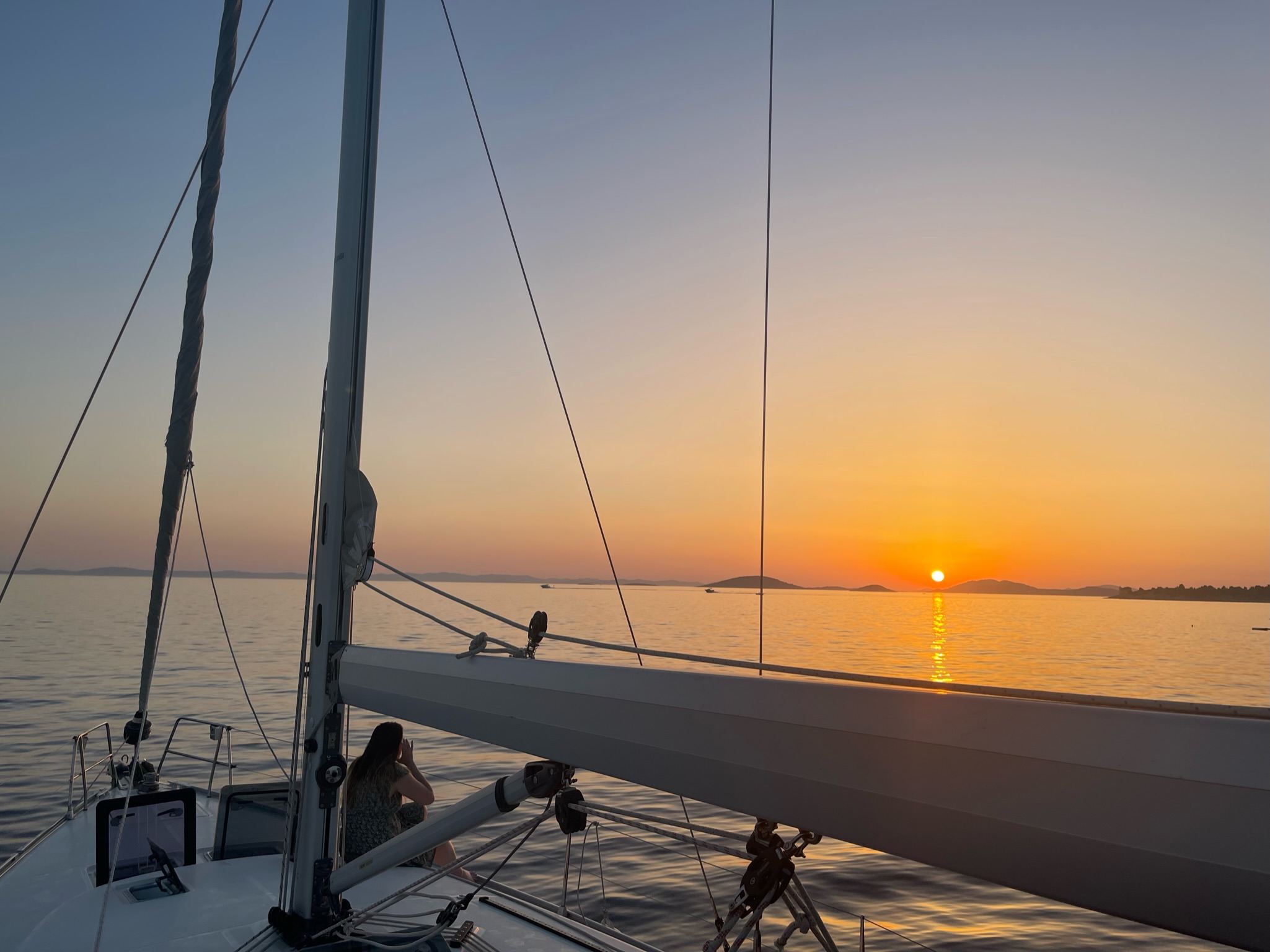 Člověk sedící na lodi při západu slunce