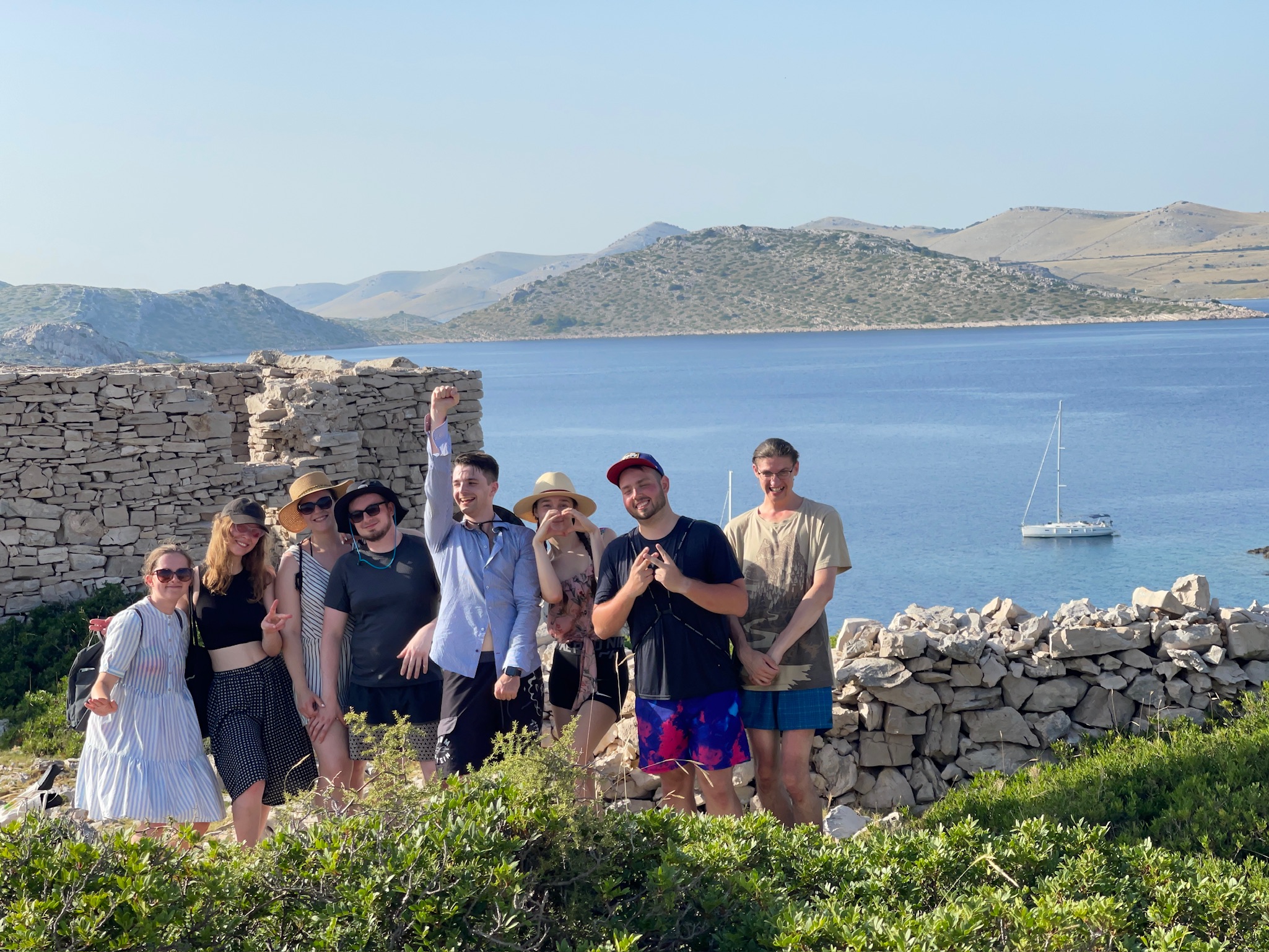 skupina lidí pózující na fotografii před vodní plochou