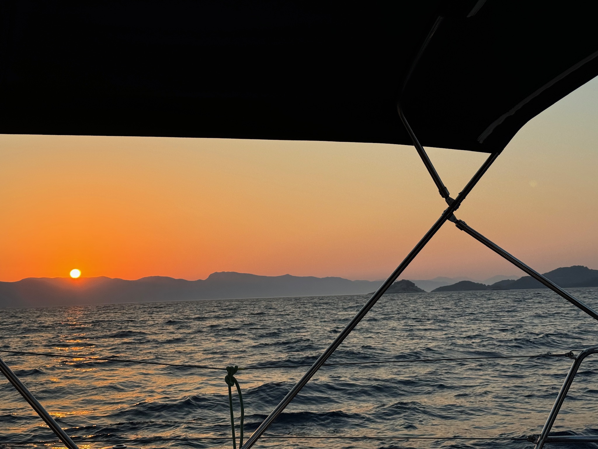 západ slunce nad vodou s lodí