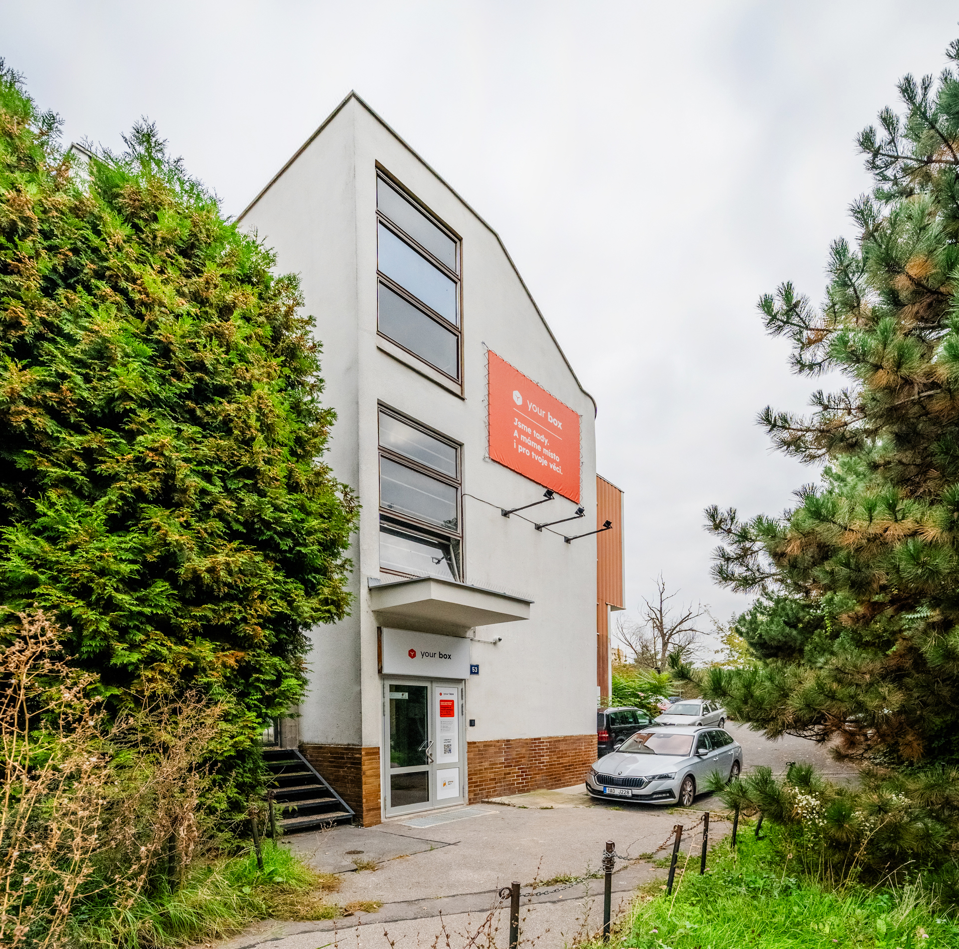 budova se stromy a cedulí