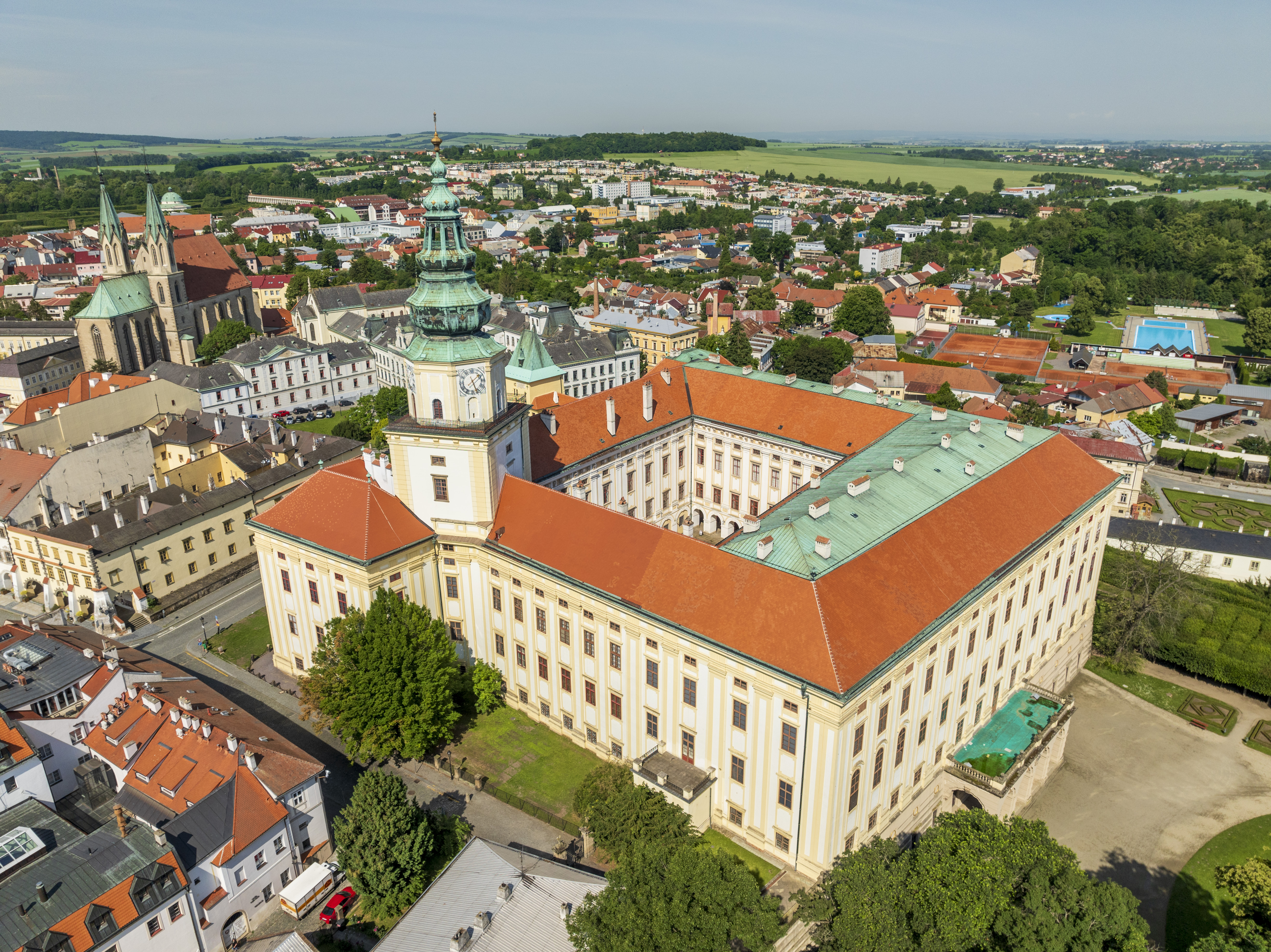 velká bílá budova se zelenou střechou a zelenou věží